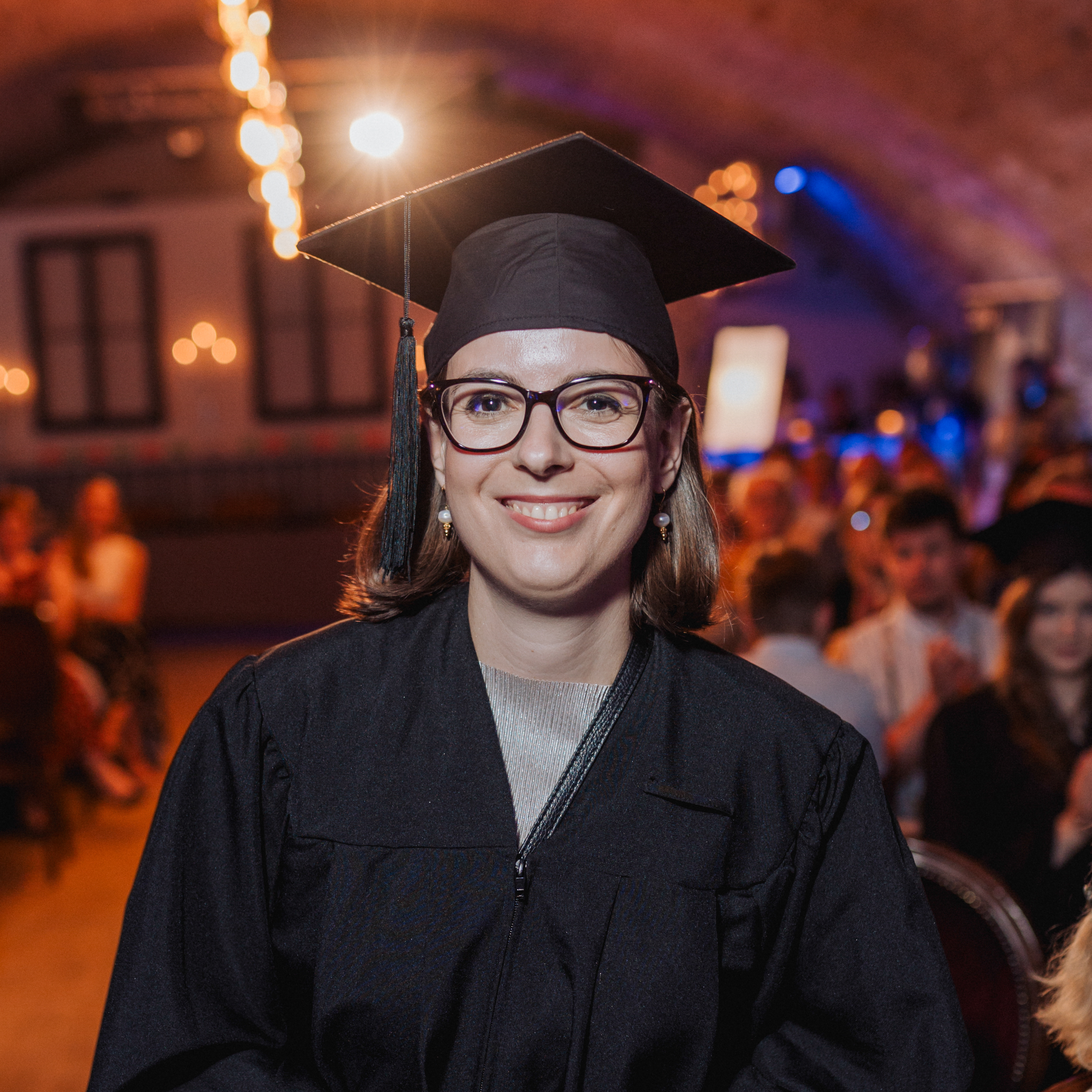 Frau in Robe mit kurzen braunen Haaren und Brille