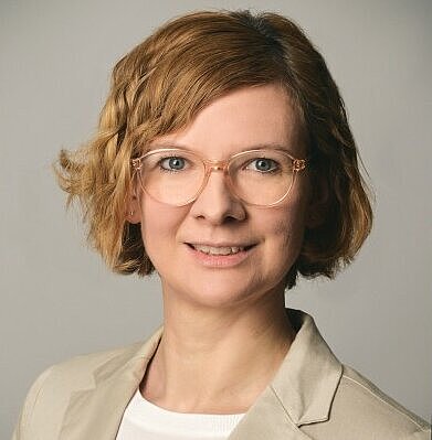 Frau mit blonden Haaren und Brille